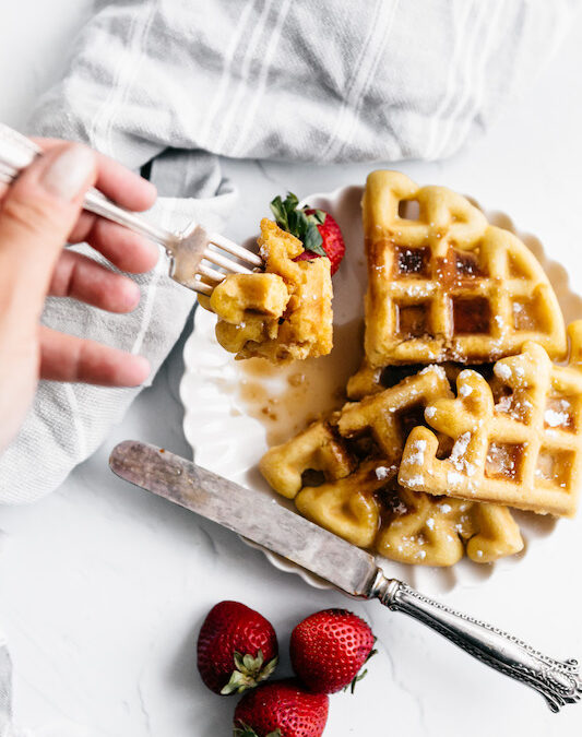 gluten free waffle with fork and hand